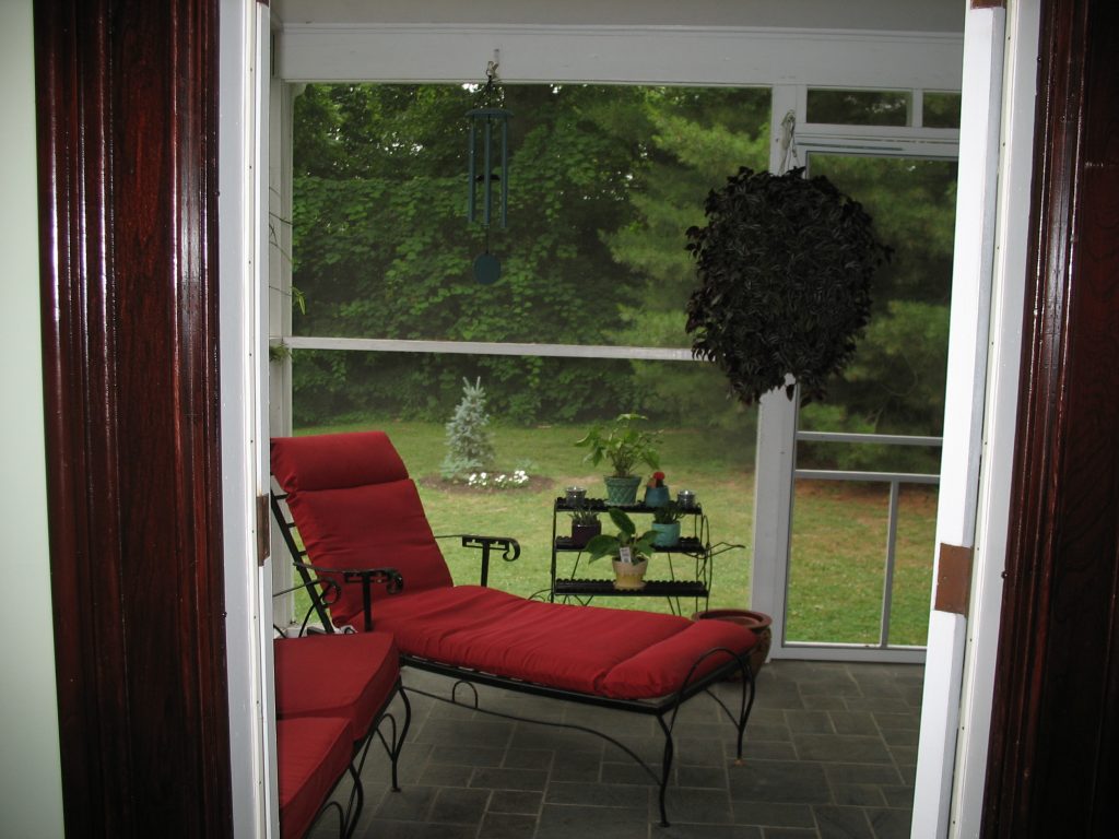 This is a view of the screened-in porch with the black metal furniture.