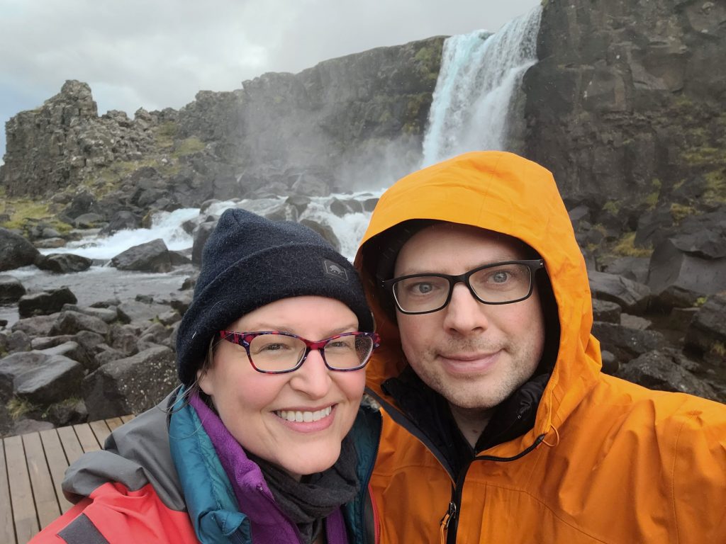 a couple in front of a waterfall