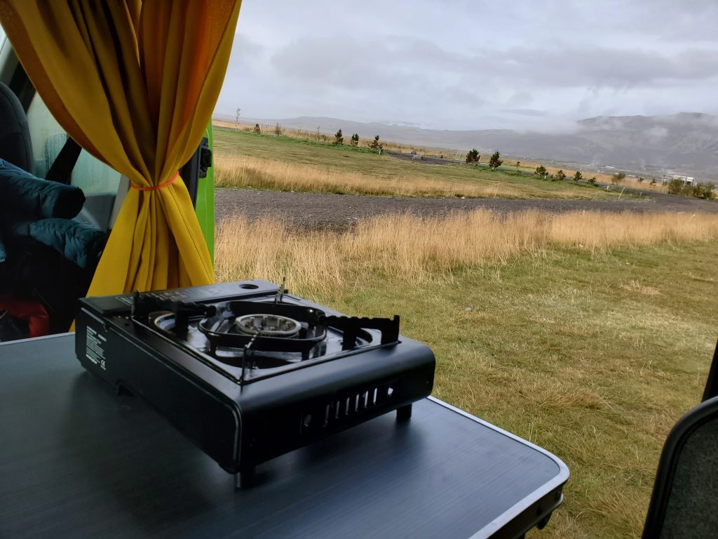 hot plate in camper van with pasture in the background