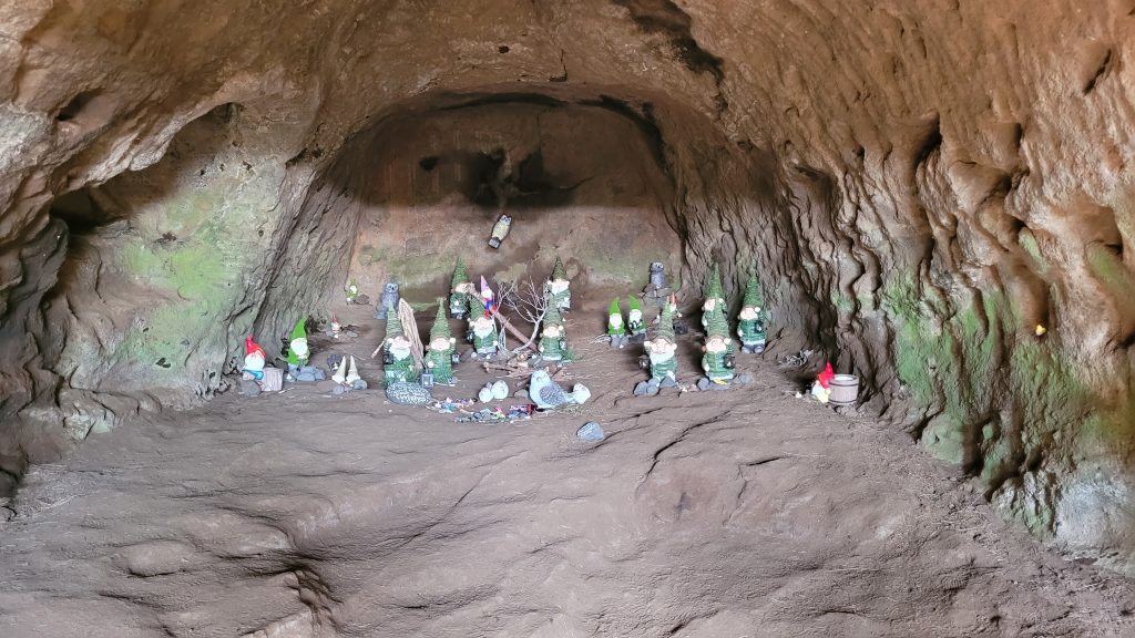 numerous gnome statues in a cave