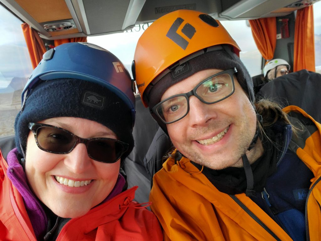 Susan and Graham dressed in glacier hiking gear on a bus