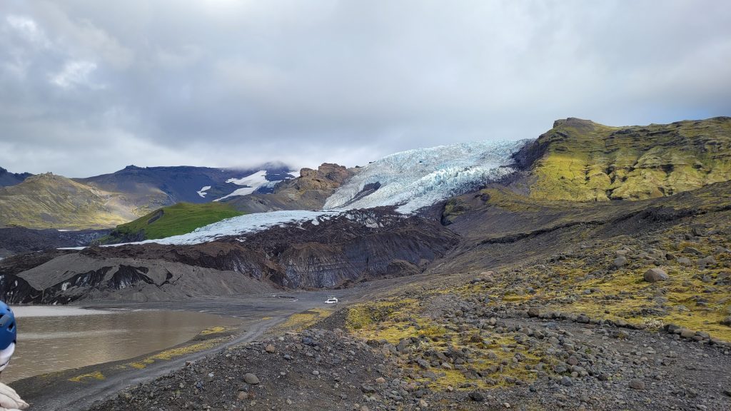 mountain with glacier cap and small parking lot below.