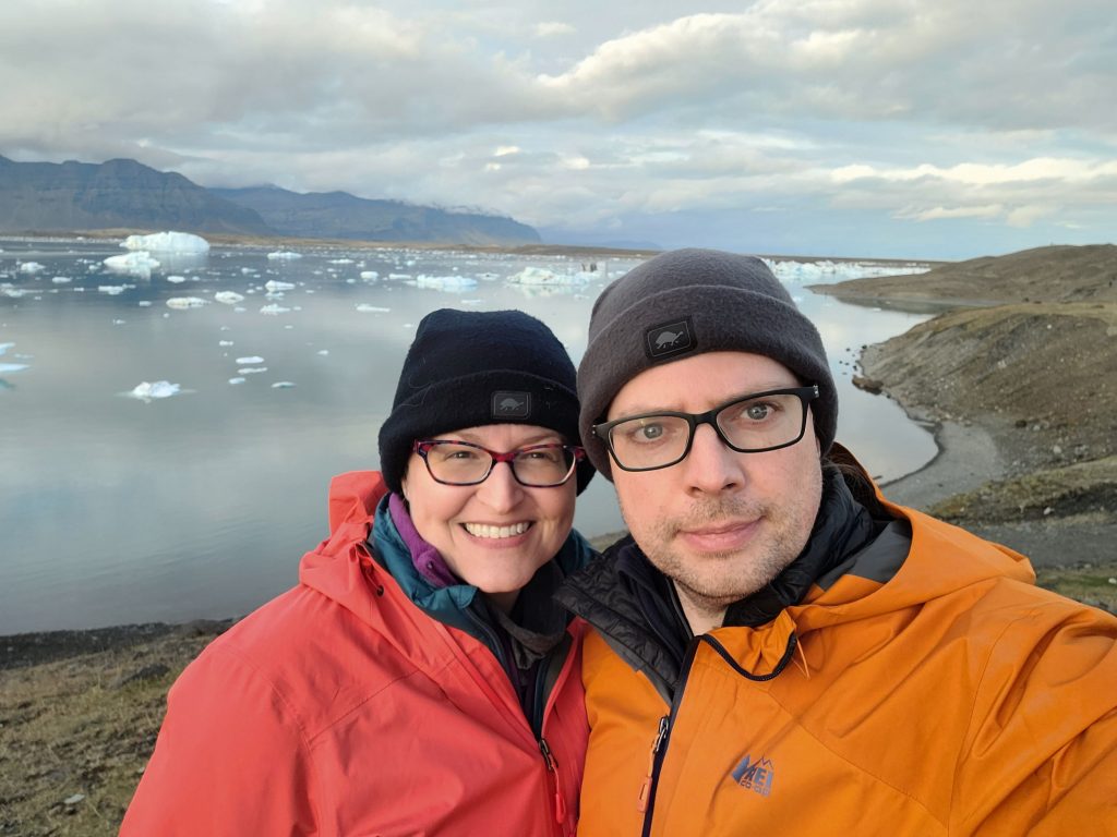 Susan and Graham with a glacier lagoon behind them.