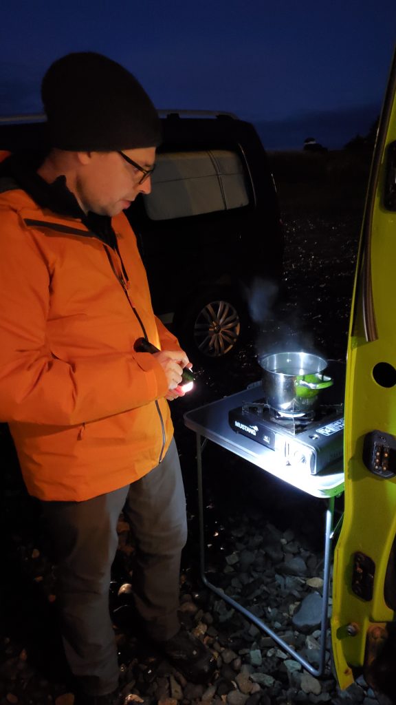 Graham cooking at our camp stove with a flash light