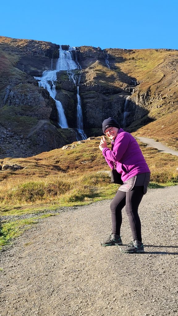 Susan pointing at a waterfall