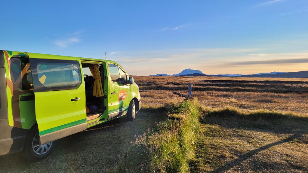 camper van with door open and farm in background