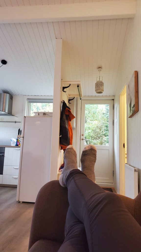 person's feet propped at the end of the couch