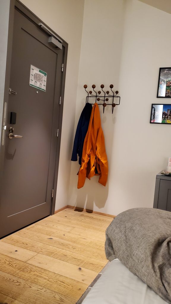 two coats hanging on a coat rack